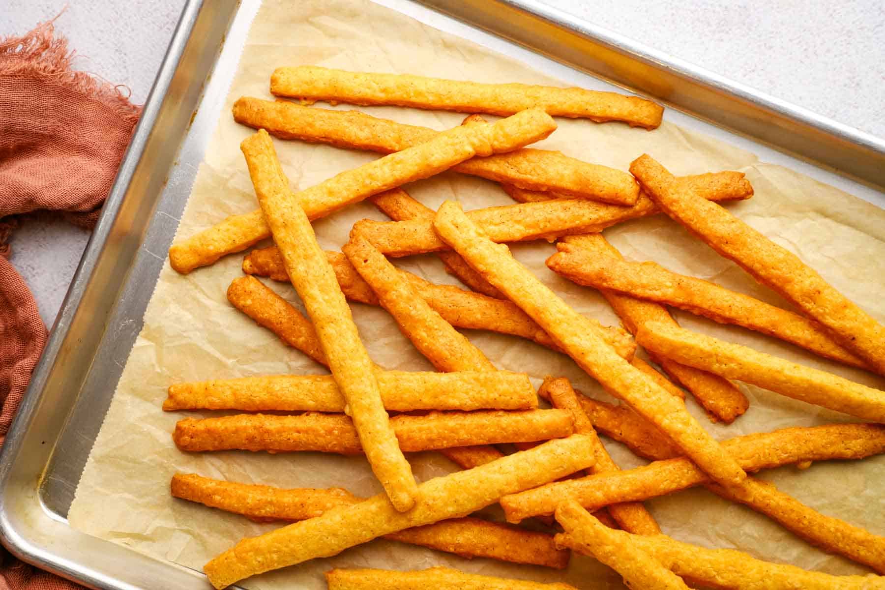 baked spicy cheese straws on a baking sheet
