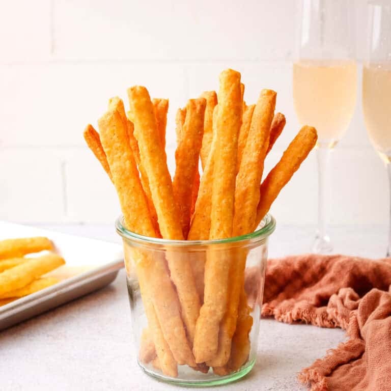 a mason jar filled with spicy cheese straws.