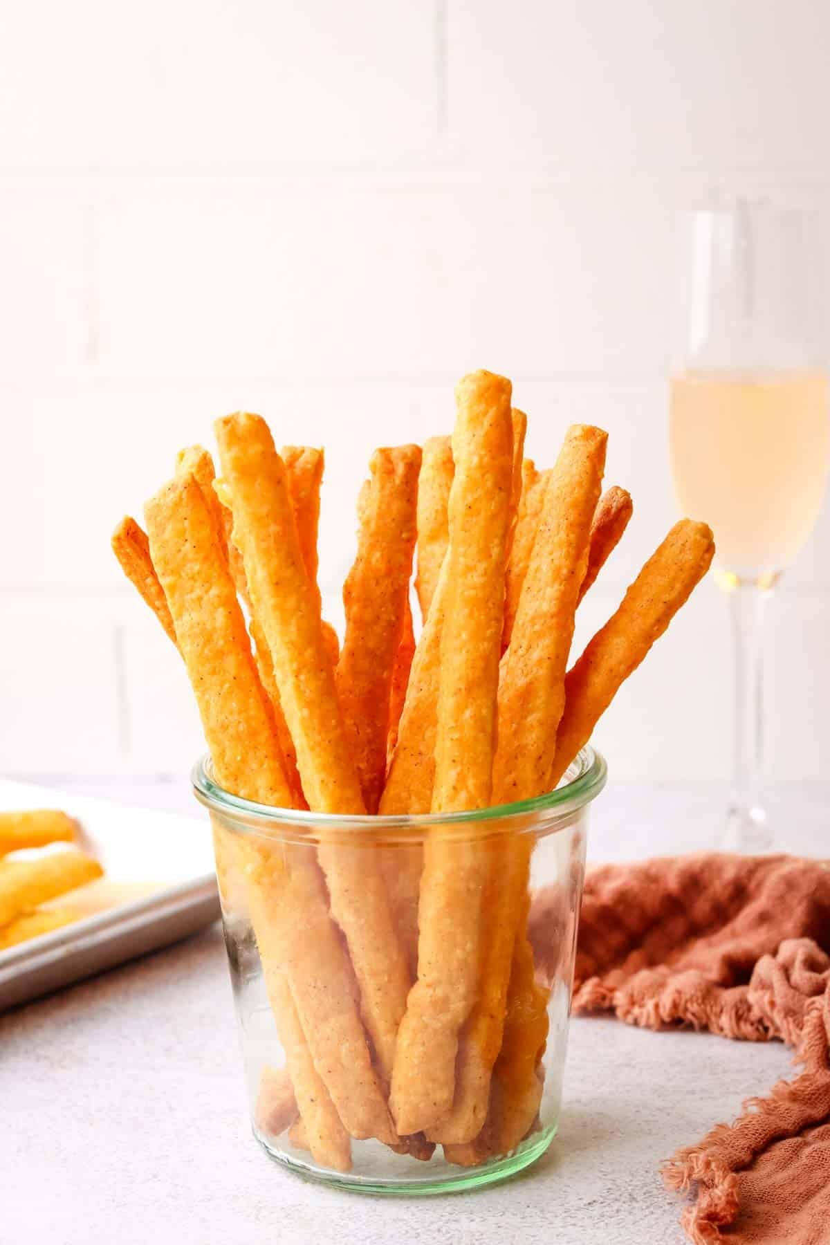 a mason jar filled with spicy cheese straws.