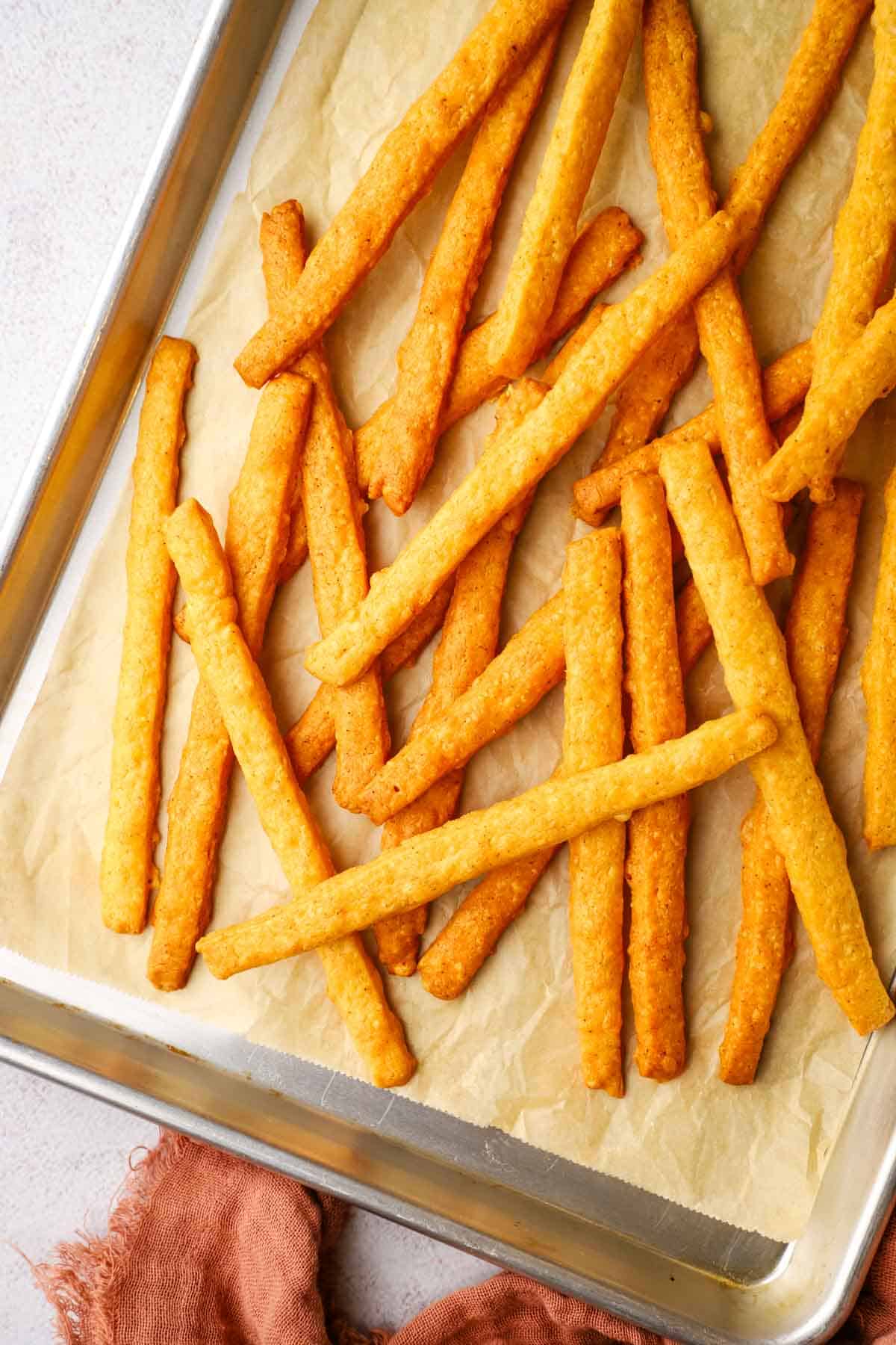 baked spicy cheese straws on a baking sheet