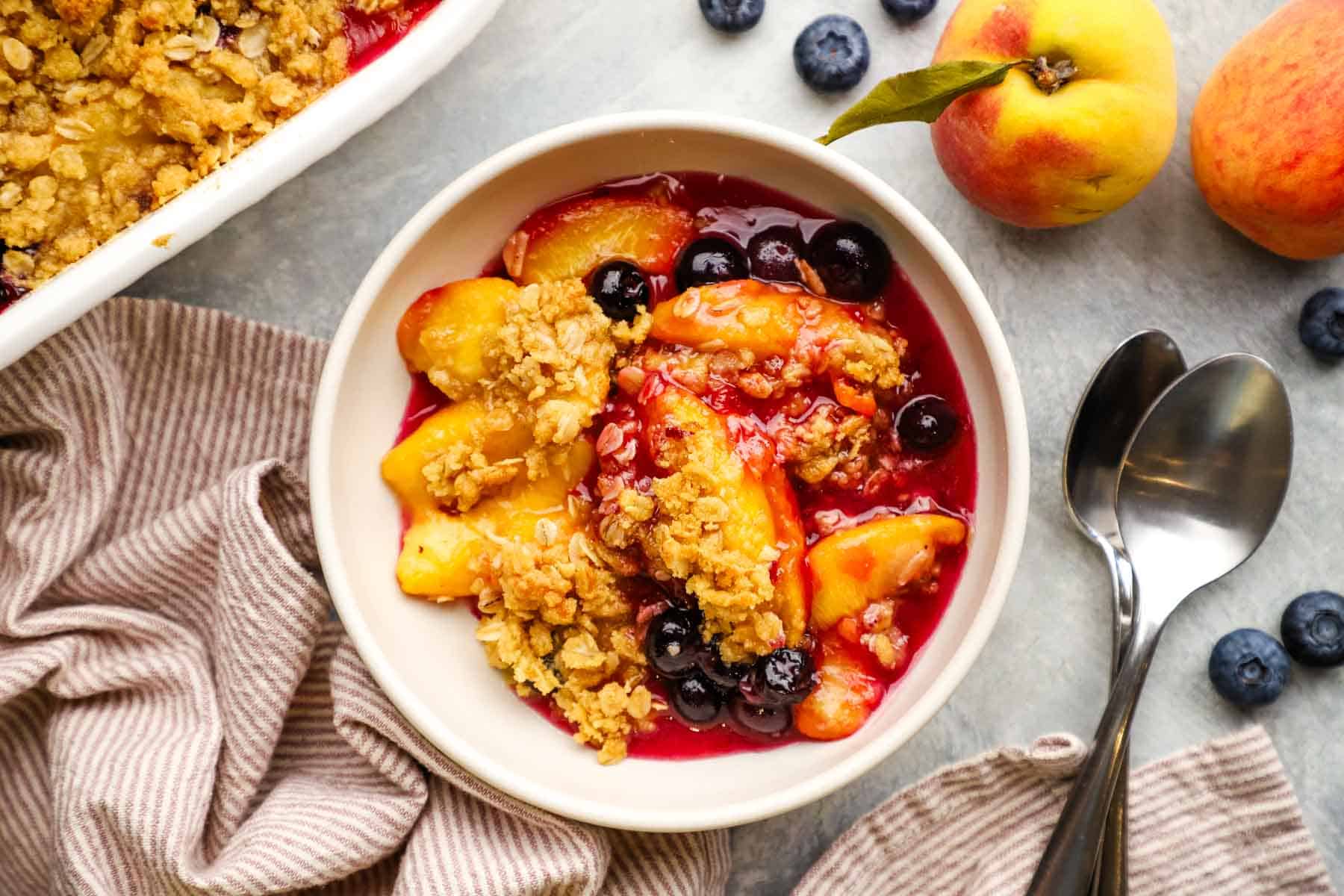 overhead view of a bowl of peach blueberry crisp.