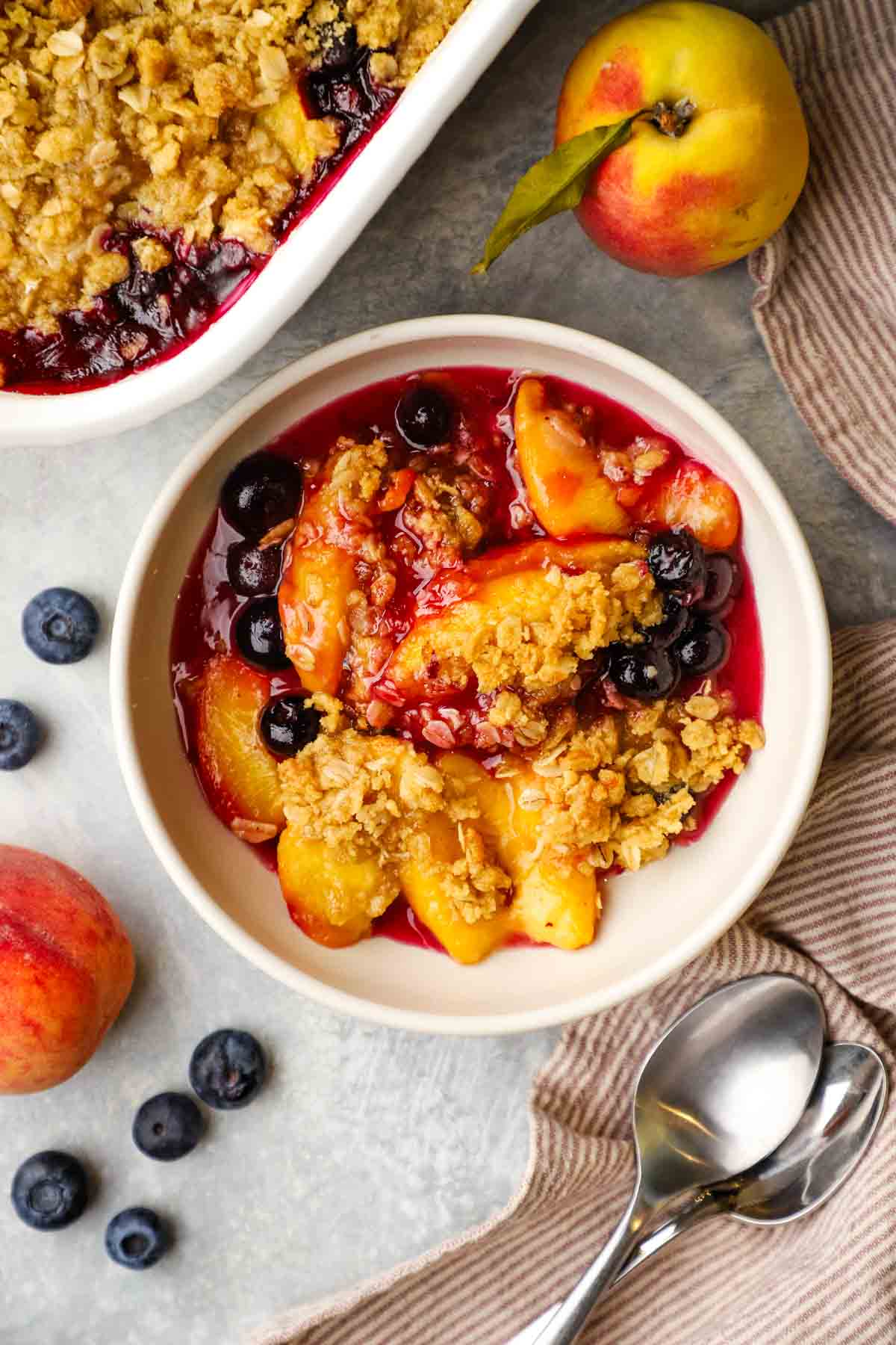 overhead view of a bowl of peach blueberry crisp.