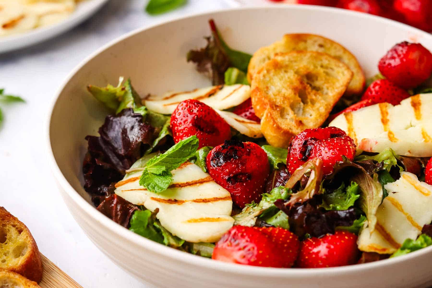a bowl of grilled strawberry halloumi salad