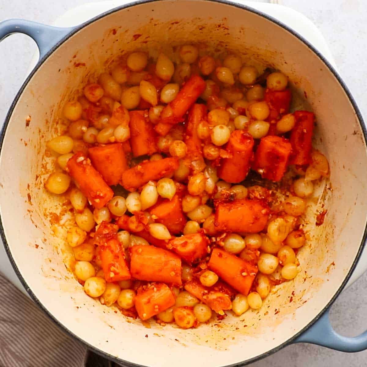 flour, tomato paste, and garlic added to the veggies in the pot