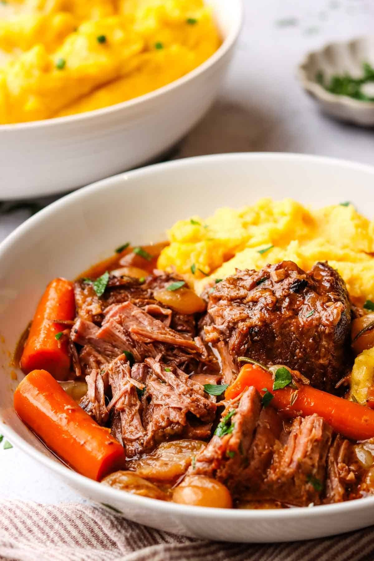a plate of mashed potatoes, braised beef and veggies