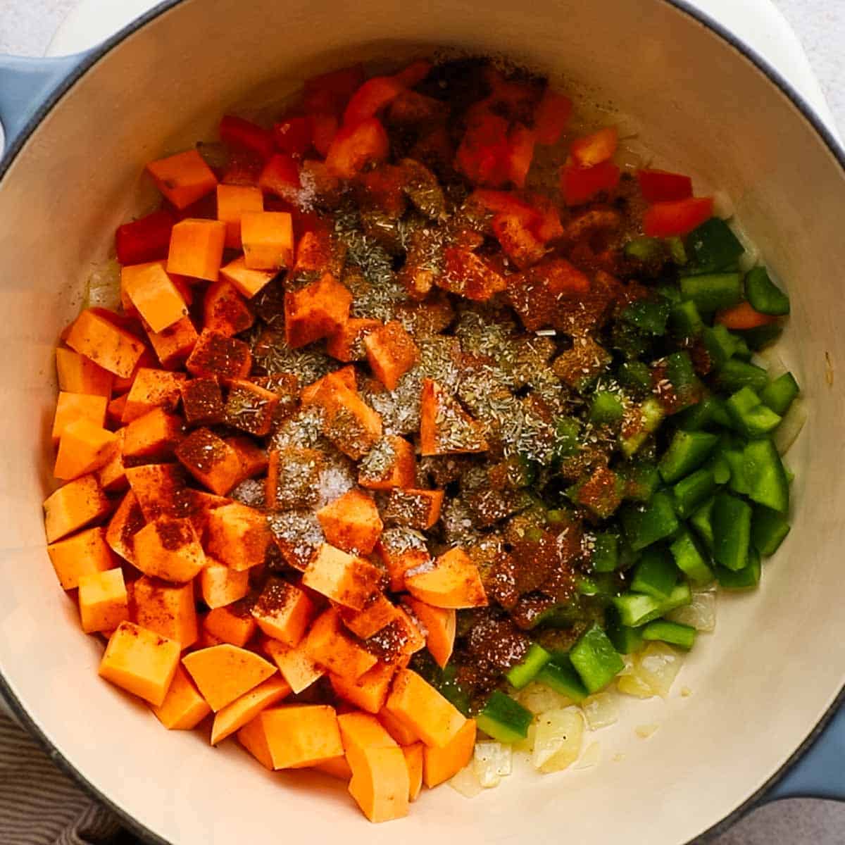 sweet potatoes and other ingredients added to the sauteed onion and garlic