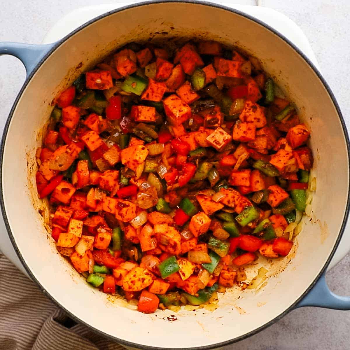 sweet potatoes being sauteed with spices and other veggies