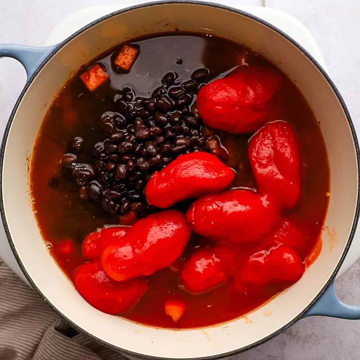 tomatoes and beans added to the pot