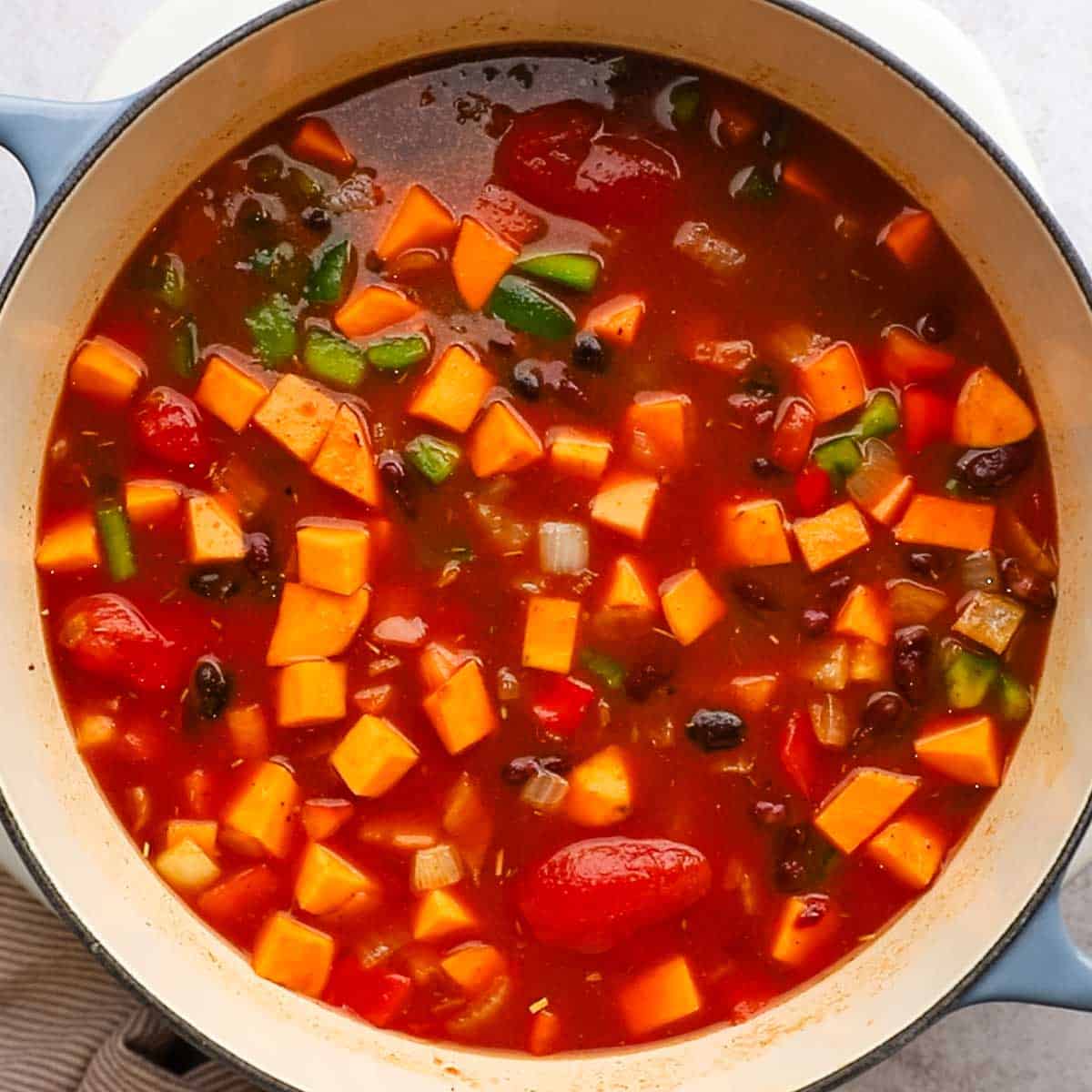 all the ingredients for sweet potato chili being simmered on the stove