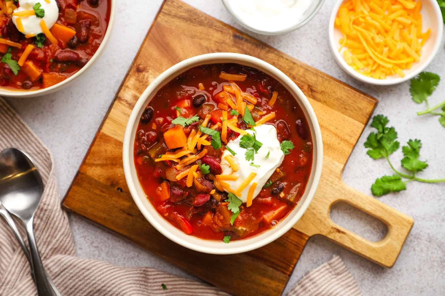 overhead view of a bowl of sweet potato chili with different toppings