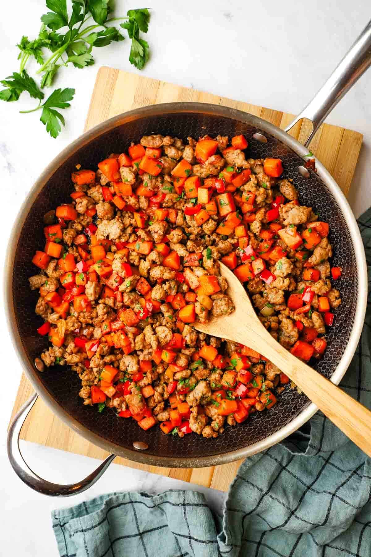 overhead view of a skillet of sweet potato and sausage hash